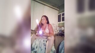 Innocent girl with long brunette wavy hair filming herself in her pink nightgown playing video games