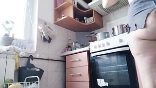 Sexy naked wife prepares food in the kitchen.