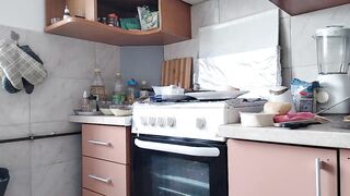 Amateur mom prepares breakfast in the kitchen naked.